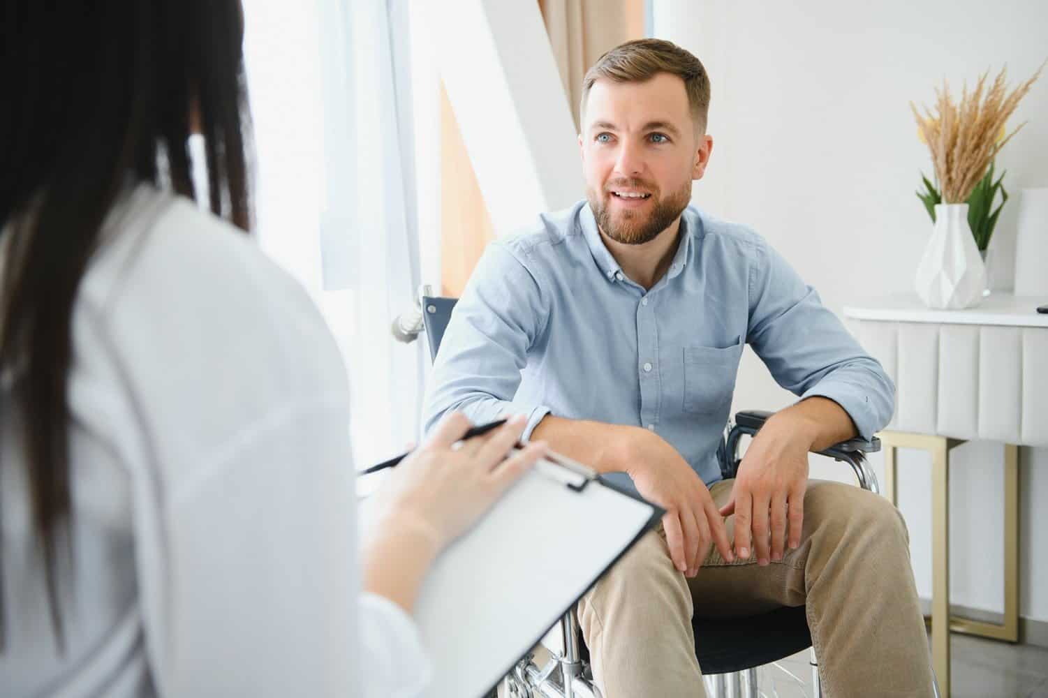 Portrait of female psychiatrist interviewing handicapped man during therapy session, copy space